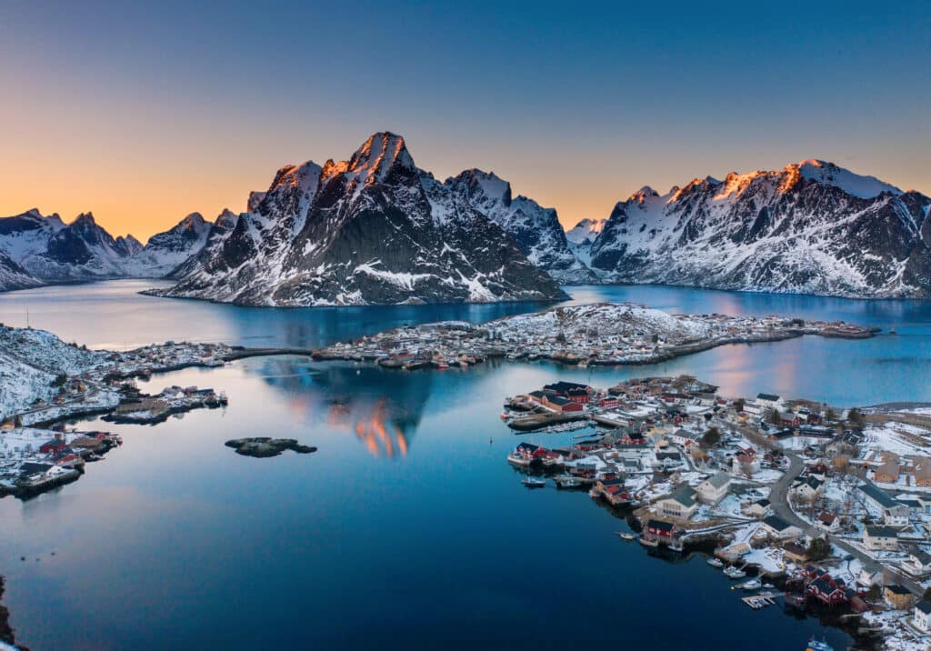 norwegian landscape with mountains and a village in a sunset